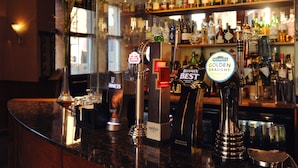 A bar counter with multiple taps, including brands like Stella Artois and Guinness. Behind the counter, shelves are stocked with various bottles of alcohol. - The Royal Highland Hotel (Inverness)