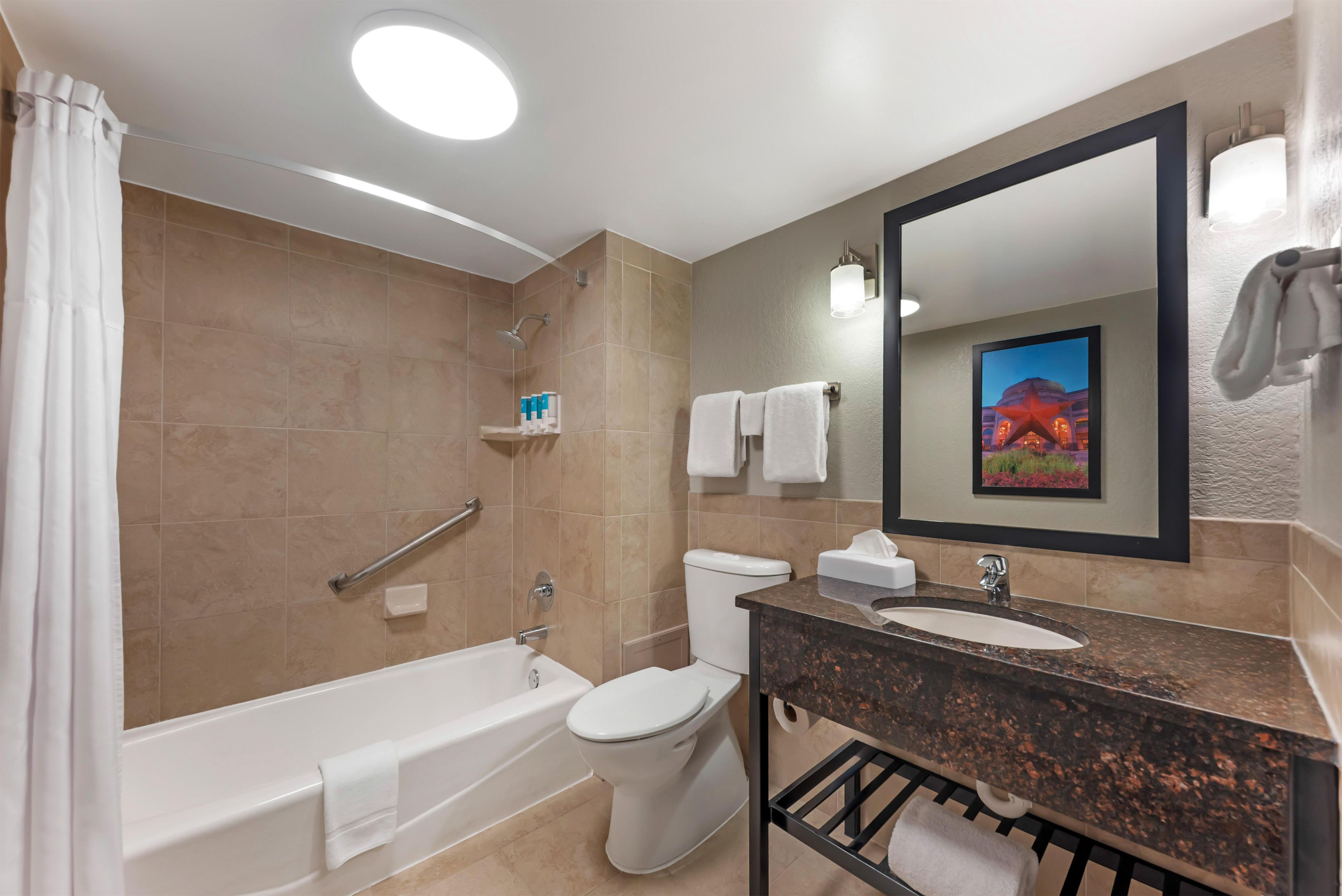 A modern bathroom with a bathtub, toilet, and sink.