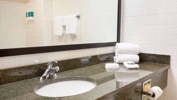 A bathroom with a sink, mirror, and towel rack.