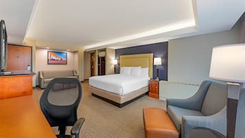 Habitación de hotel con cama, escritorio, silla y vistas a la ciudad.