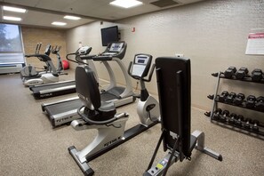 A gym with treadmills, elliptical machines, a stationary bike, and a rack of dumbbells. - Drury Inn & Suites Austin North (Austin)