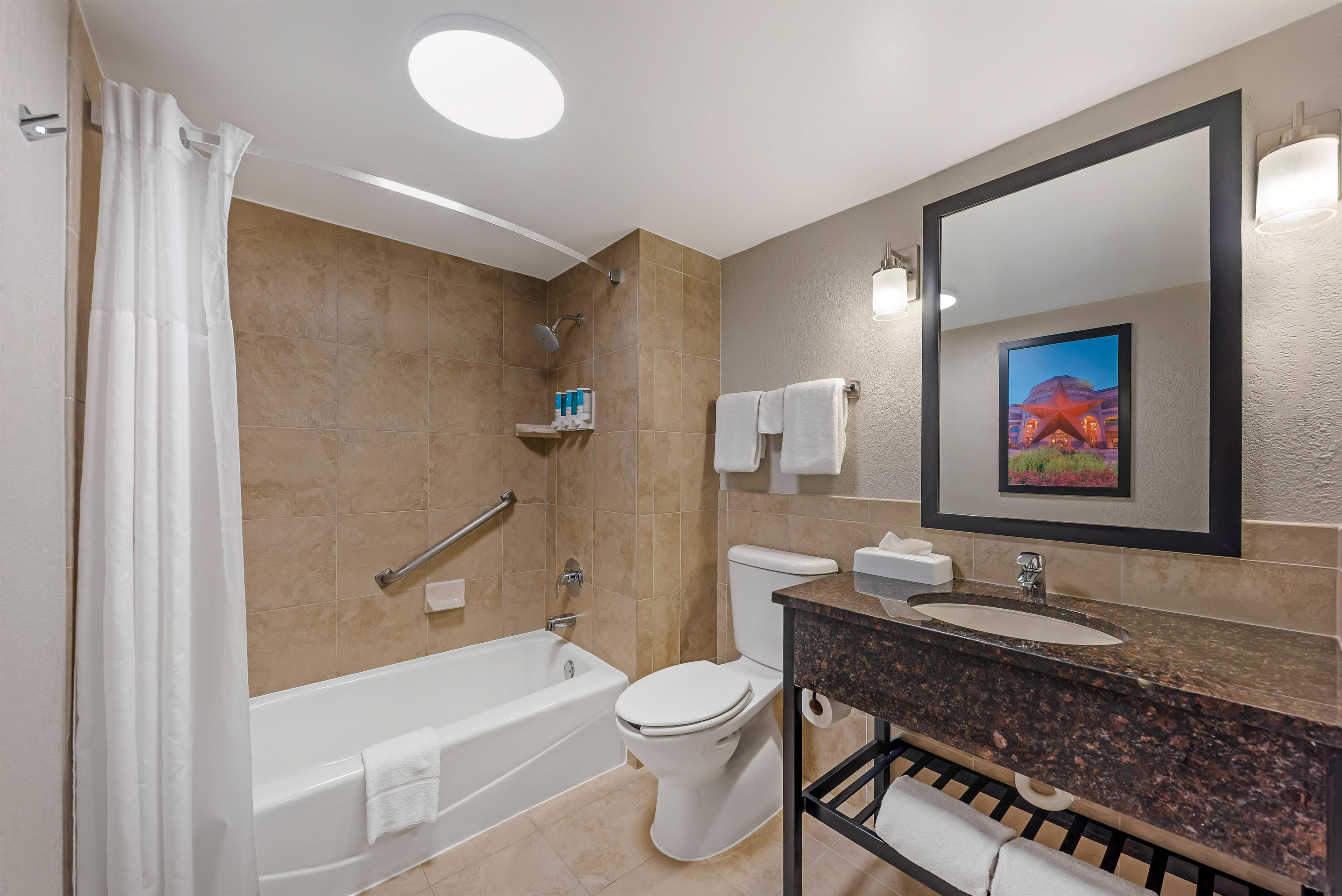 Une salle de bain moderne équipée d’une baignoire, de toilettes et d’un lavabo.
