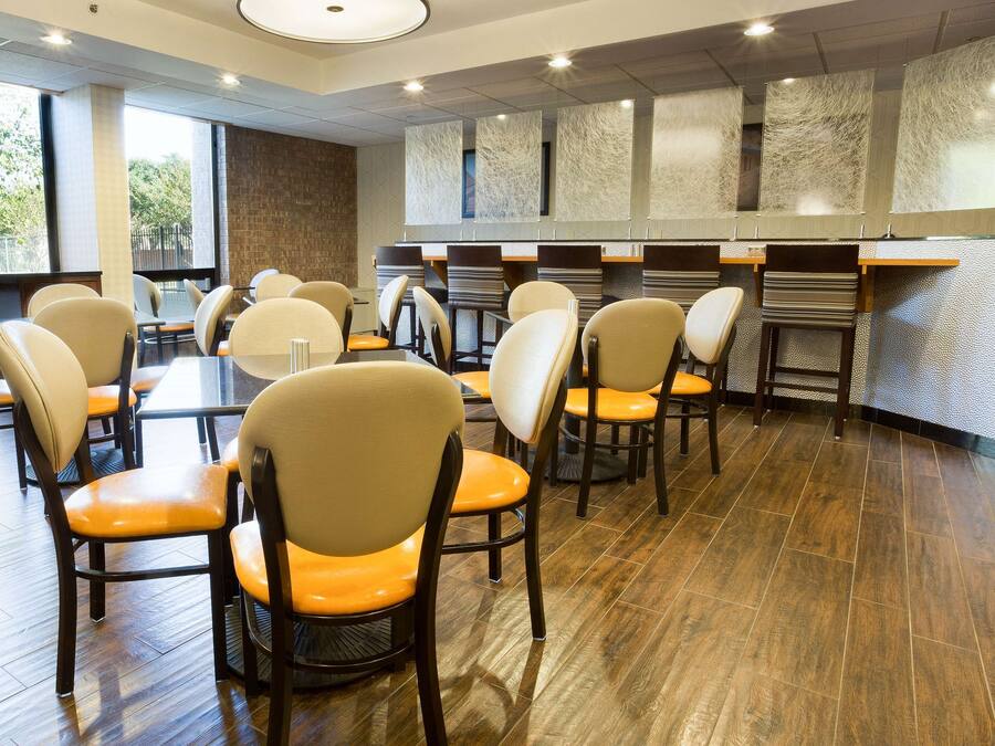 Un restaurant avec plusieurs tables et chaises, un mur en briques et un mur orné d’un motif.