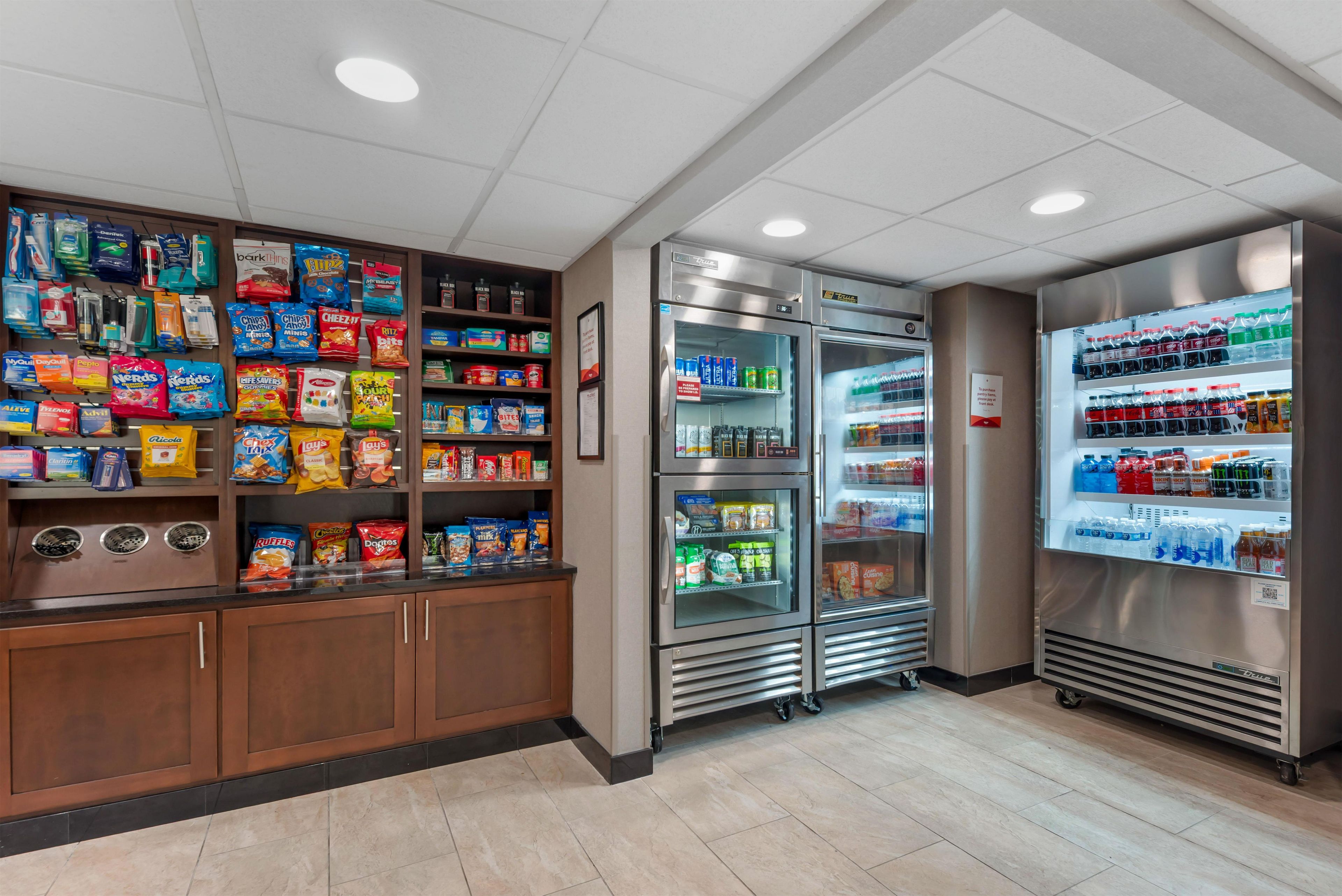 Un espace proposant des distributeurs automatiques de collations et de boissons, avec un assortiment de produits emballés.