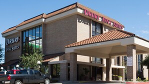 A Drury Inn & Suites building with a brick facade, large windows, and a covered entrance.
