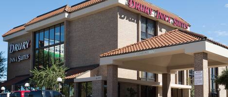 A Drury Inn & Suites building with a brick facade, large windows, and a covered entrance.