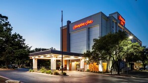 A Hampton Inn hotel with a well-lit entrance and a clear view of the parking area. - Hampton Inn Austin NW near The Domain (Austin)