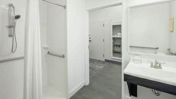 A modern bathroom with a shower, a sink, and a mirror.