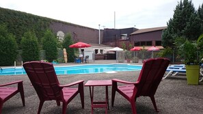 Piscine extérieure en saison, chaises longues