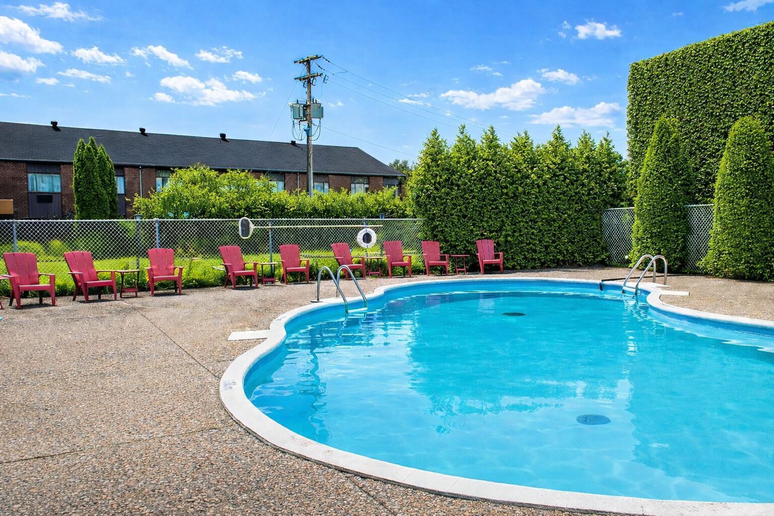 Una piscina al aire libre de temporada, sillones reclinables de piscina