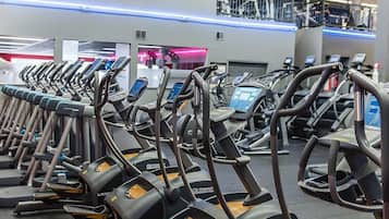 Un gimnasio con varias cintas de correr alineadas.