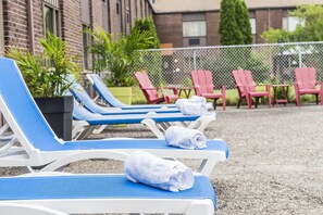 Piscine extérieure en saison, chaises longues