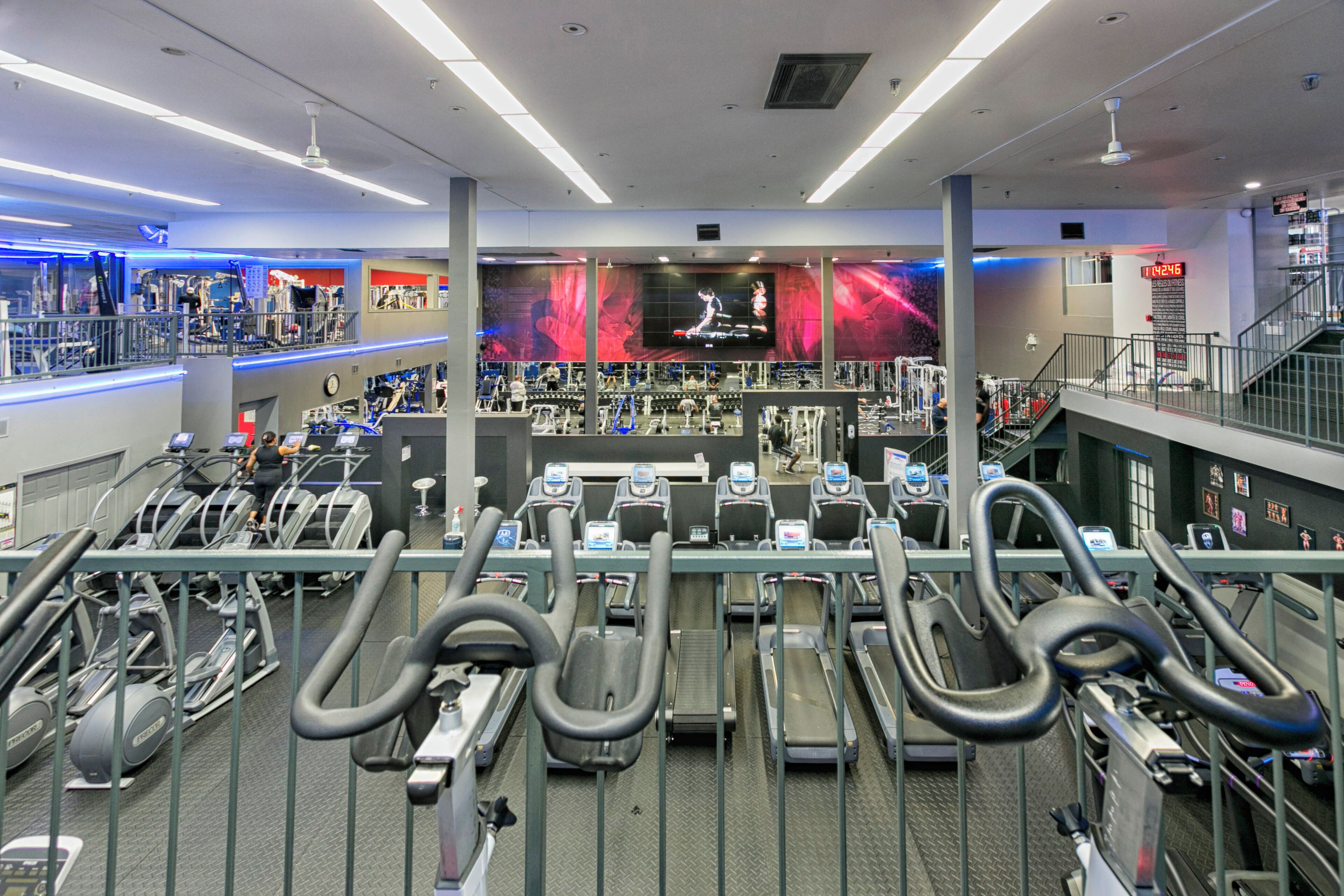 A gym with multiple treadmills, stationary bikes, and weight machines.
