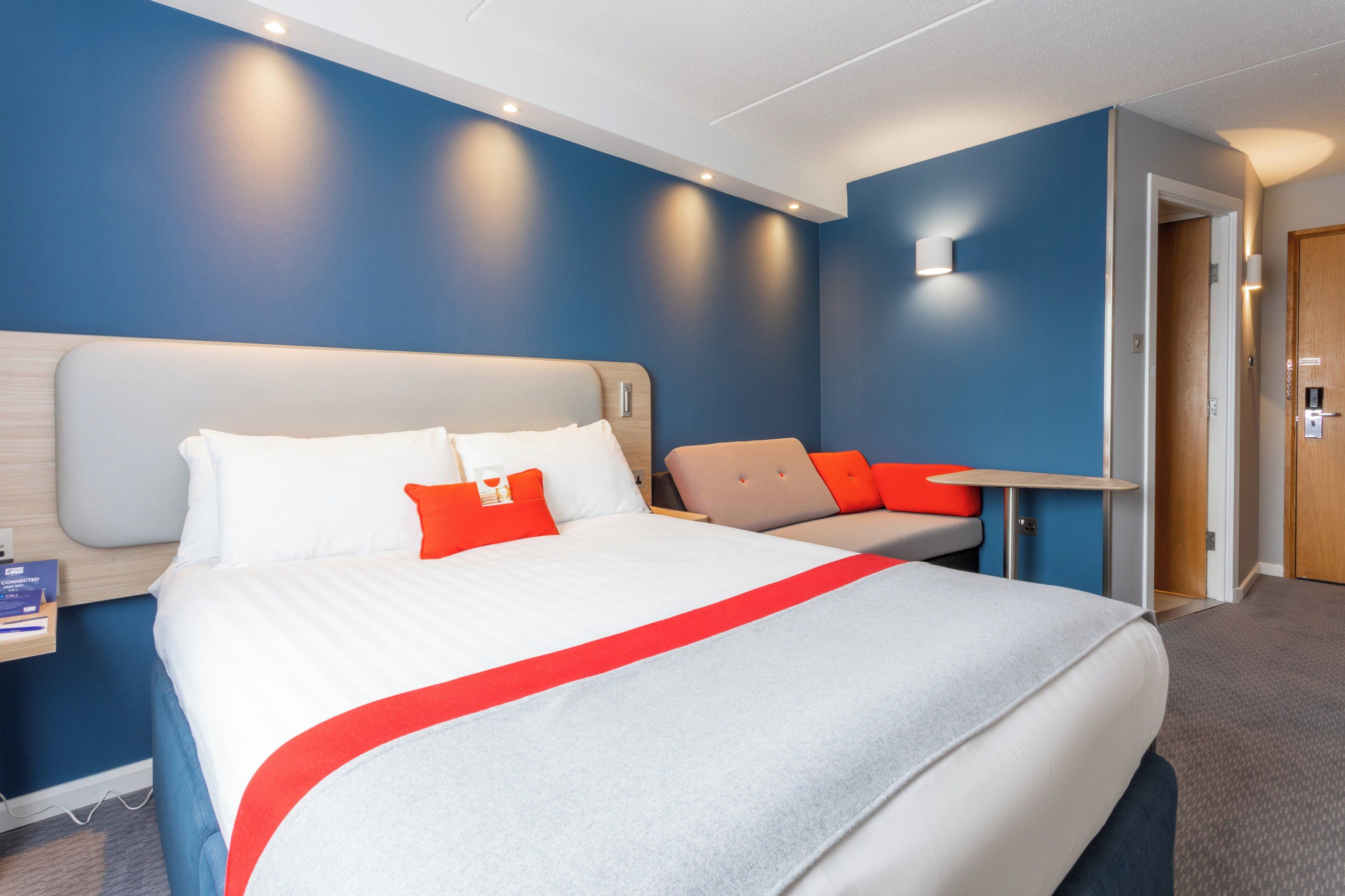 Una habitación de hotel con una cama grande, un escritorio y una silla.