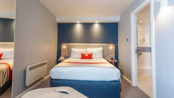 A hotel room with a bed, bedside tables, a nightstand, a desk, and a shower area.