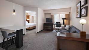 A hotel room with a bed, a desk with two chairs, a sofa, a TV, and a lamp. - Residence Inn by Marriott Austin The Domain Area (Austin)