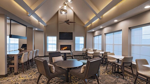 A spacious conference room with a large table, multiple chairs, a fireplace, and large windows. - Residence Inn by Marriott Austin The Domain Area (Austin)