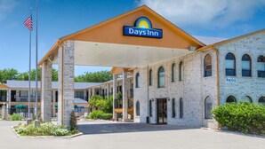 Ett Days Inn-hotell med en klarblå himmel, en amerikansk flagga och en fasad av tegel.