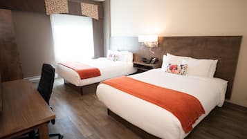 Une chambre d’hôtel avec deux lits, un bureau et une chaise.