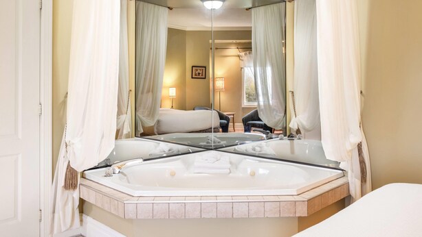 Un baño con un espejo grande, una bañera y zona de ducha.