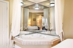Un baño con un espejo grande, una bañera y zona de ducha.