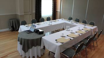 A conference room with a long table, chairs, and a laptop on one side.