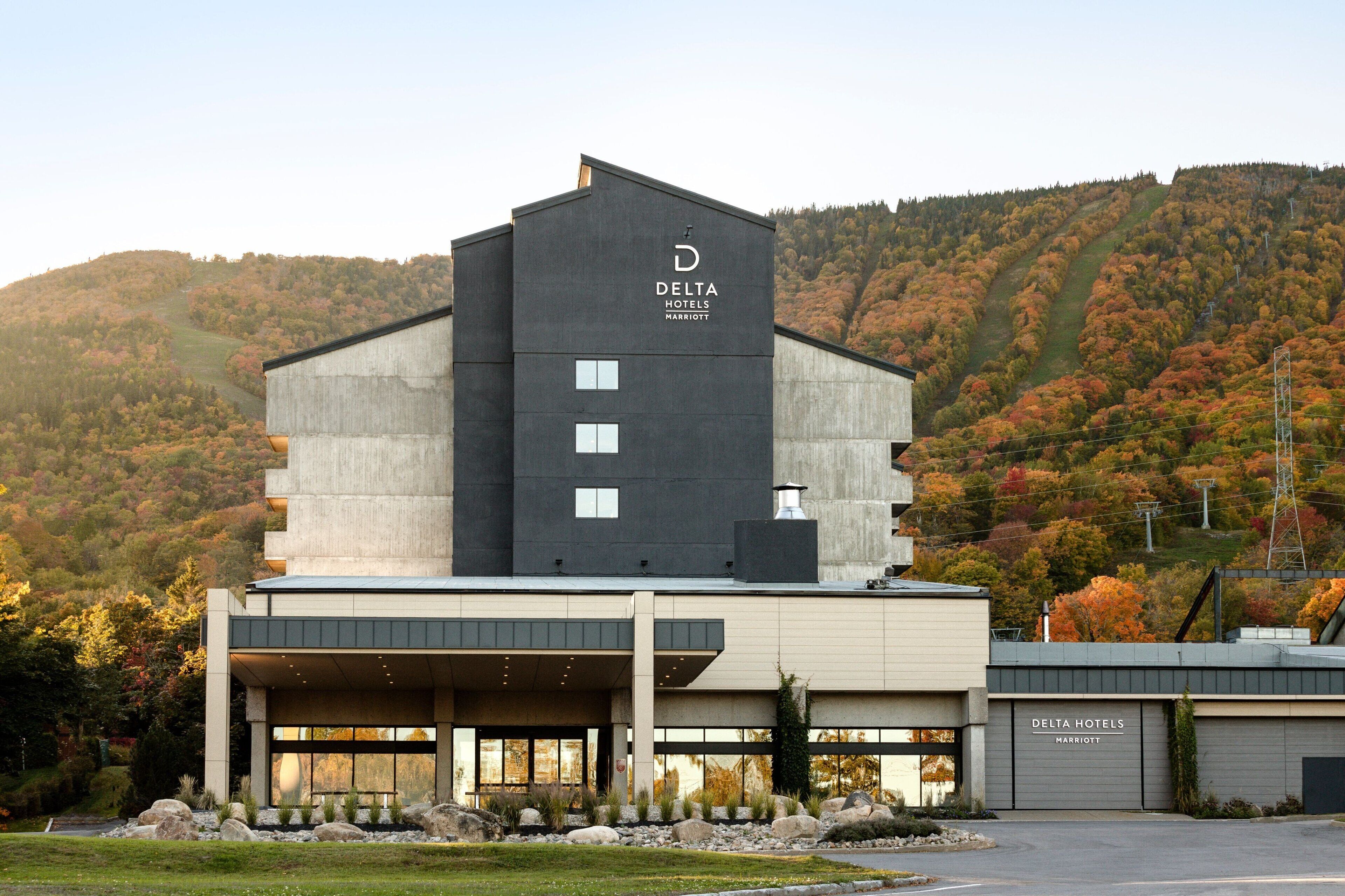 A modern Delta Hotels Marriott building with a prominent 'D' logo, large windows, and a flat roof.