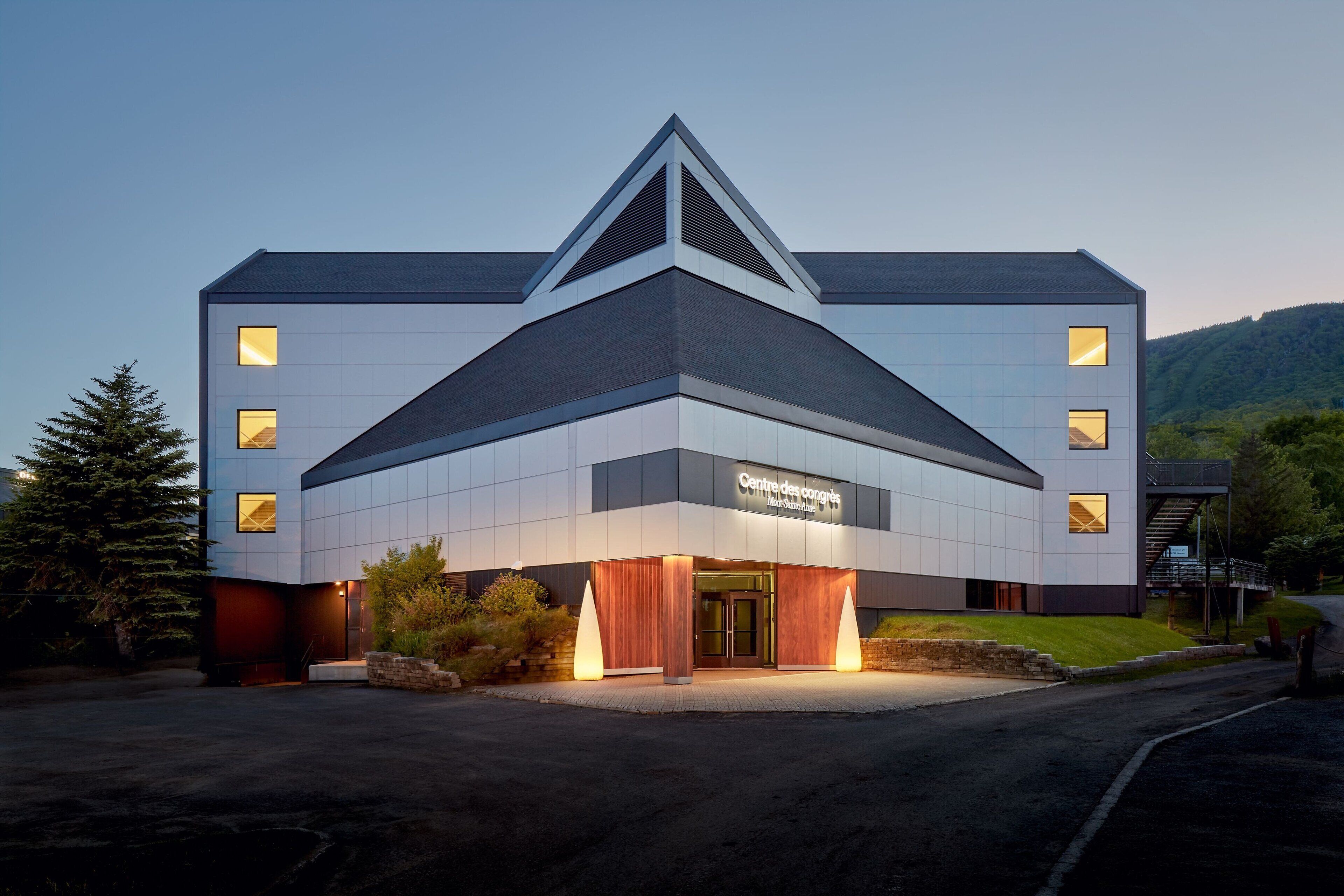 A modern building with a triangular roof, large windows, and a sign reading "Centre des congrès".