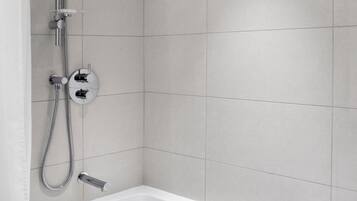 A modern bathroom with a shower, a bathtub, and a built-in toilet.