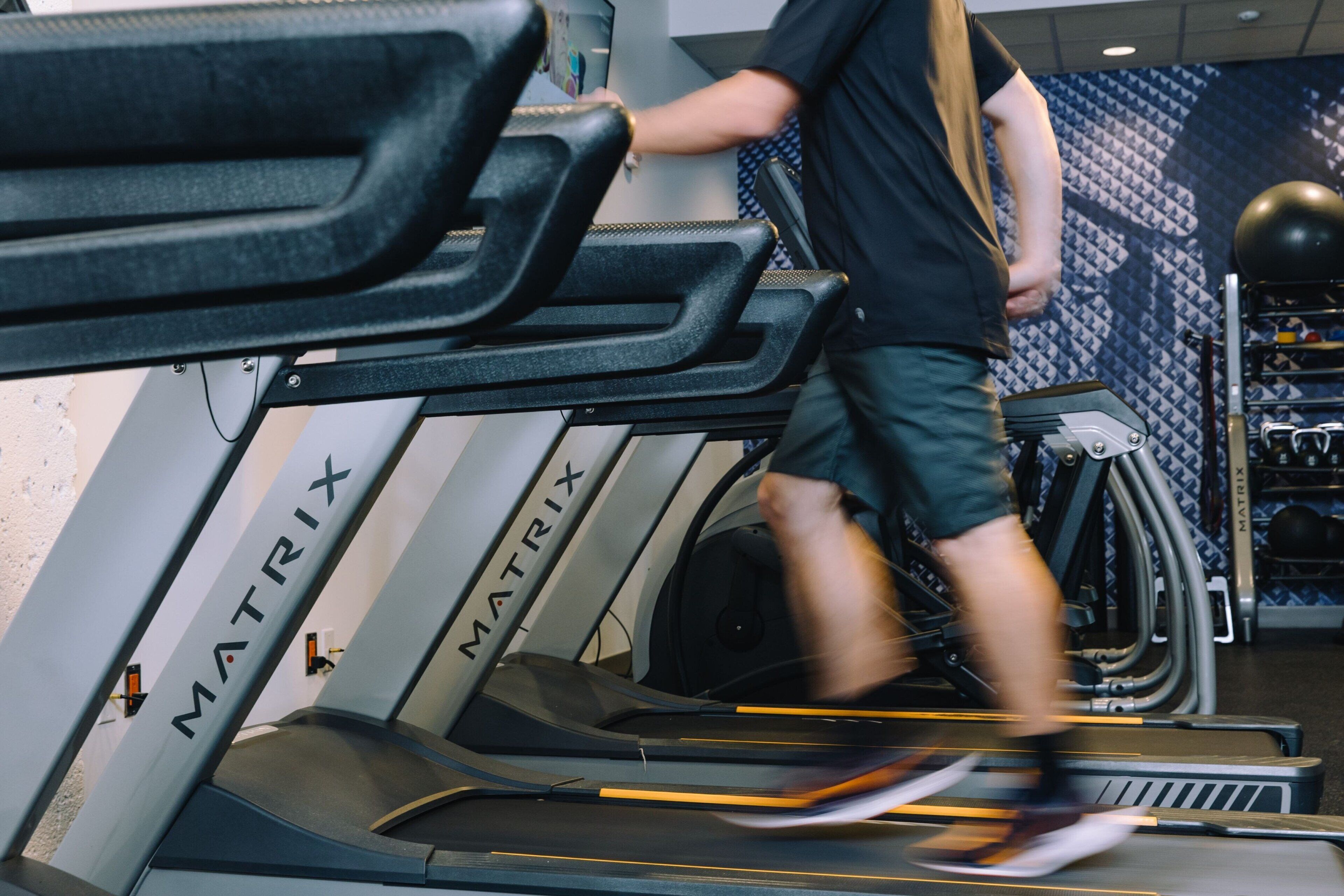 A treadmill in a gym with the brand name MATRIX visible on the side.
