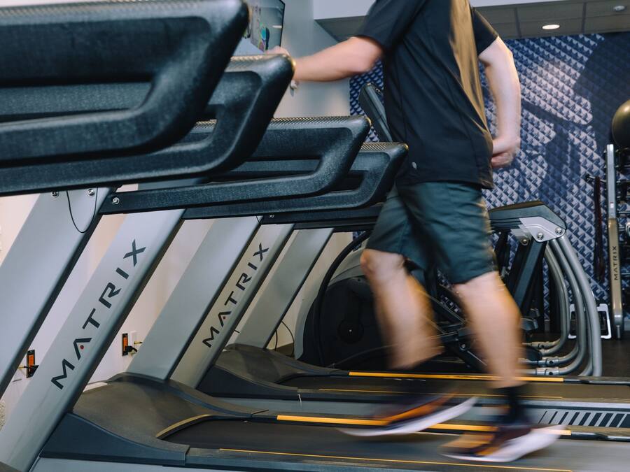 A treadmill in a gym with the brand name MATRIX visible on the side.