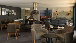 Uma área de estar moderna com lareira, assentos confortáveis e um bar.
