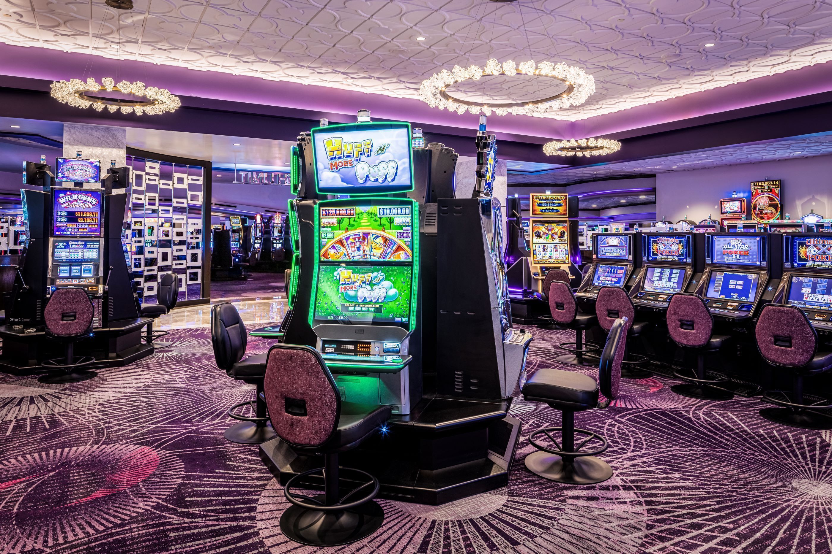 A casino floor with multiple slot machines, including 'Huff & Puff' and 'All Star', and a carpeted floor with a geometric pattern.
