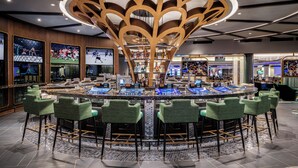 A bar area with a circular bar, green bar stools, and a unique ceiling design. - Harrah’s Las Vegas – A Caesars Rewards Destination (Las Vegas)