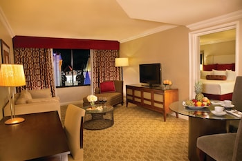 A hotel room with a view of a cityscape, including a distinctive building with a blue roof. at Excalibur Hotel & Casino