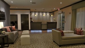 A spacious lobby with a reception desk, sofas, and a patterned carpet. - Baymont by Wyndham Dallas/ Love Field (Dallas)