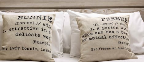 Two pillows with definitions of 'BONNIE' and 'FREENS' on a bed.