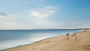 A beach with people walking and playing, a clear sky, and a calm sea. - Mercure Ayr Hotel (Ayr)