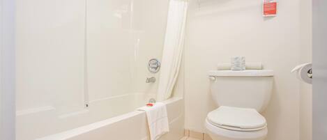 Un baño con bañera, inodoro y toallero.