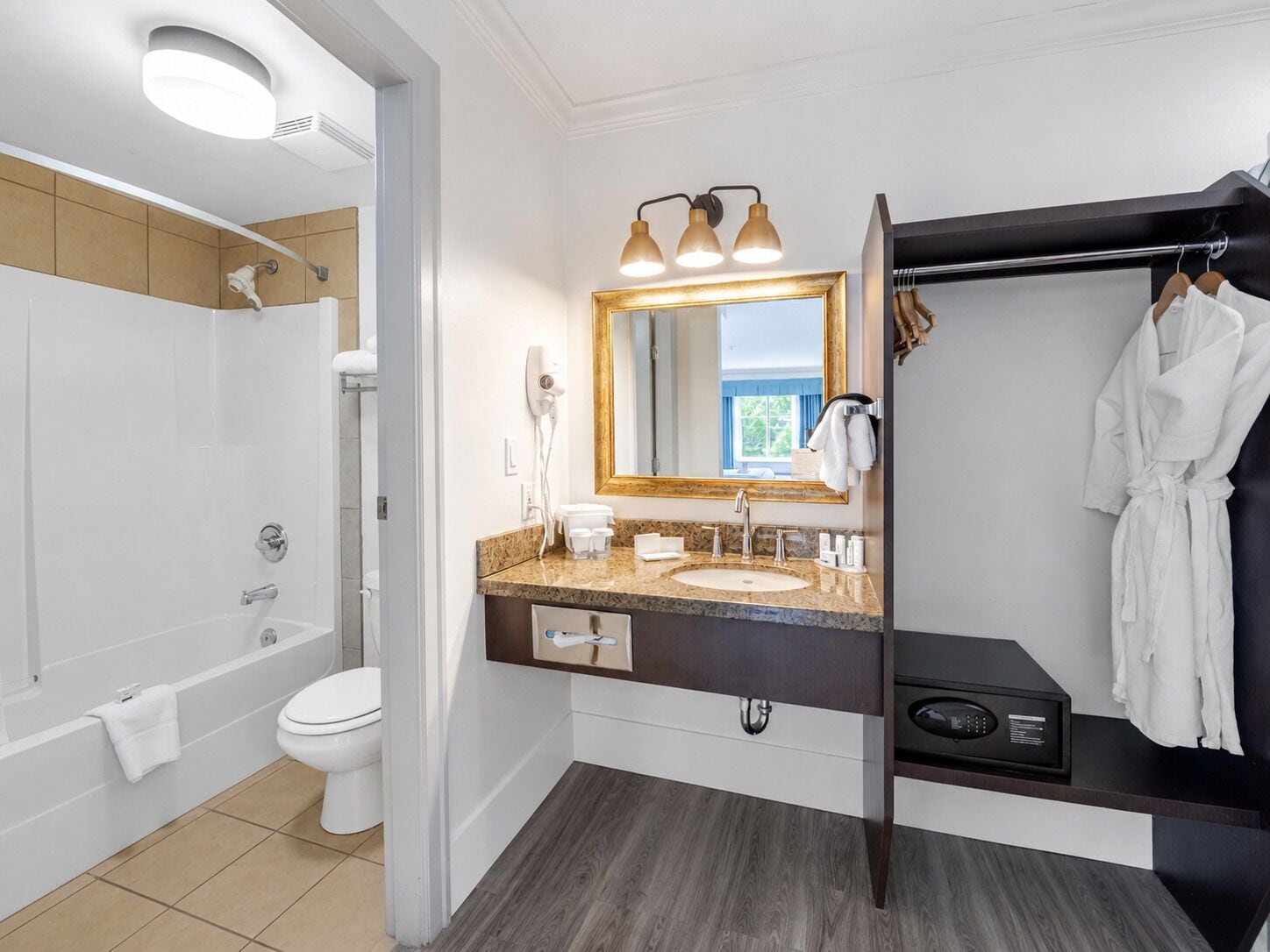 A modern bathroom with a bathtub, toilet, vanity with a sink, and a mirror.