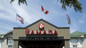 A building with the sign "RAMADA" and three flags on top. - Ramada by Wyndham Surrey/Langley (Surrey)