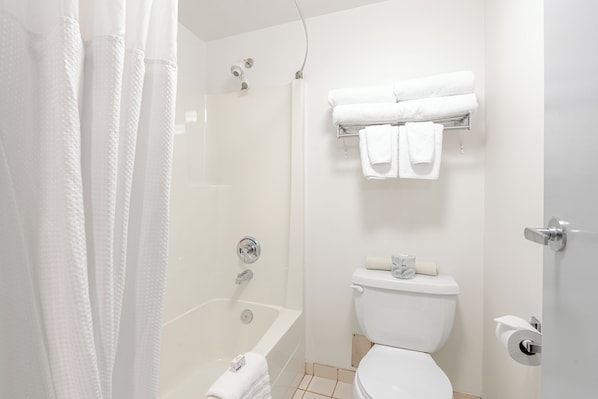 Un baño moderno con bañera, inodoro y toallero.
