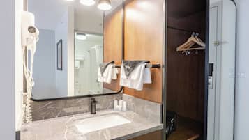 A bathroom with a marble sink, a large mirror, and a wooden vanity.