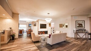 A modern hotel room with a fireplace, a dining area, and a living room with a sofa and coffee table. - Best Western Mountainview Inn (Golden)