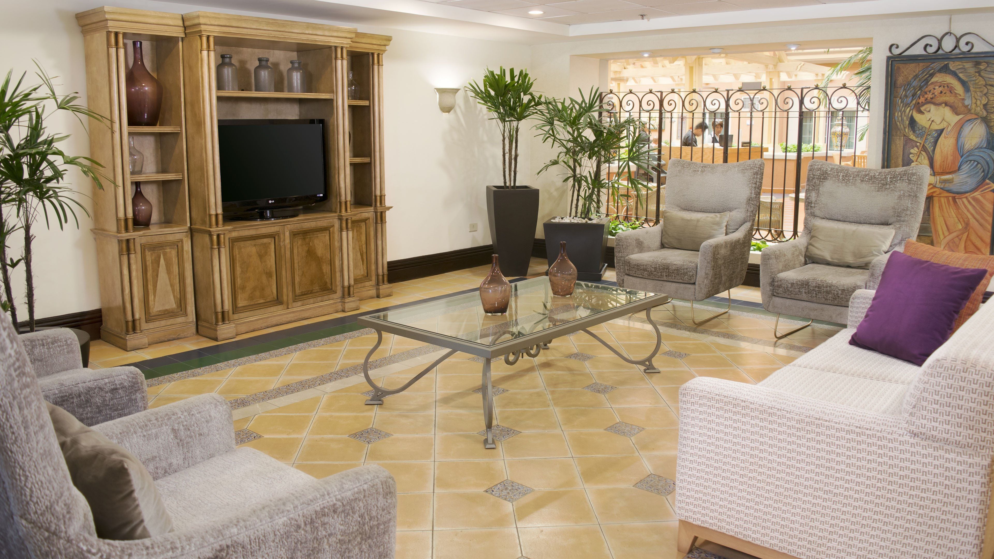Una sala de estar con televisor, asientos y objetos decorativos.