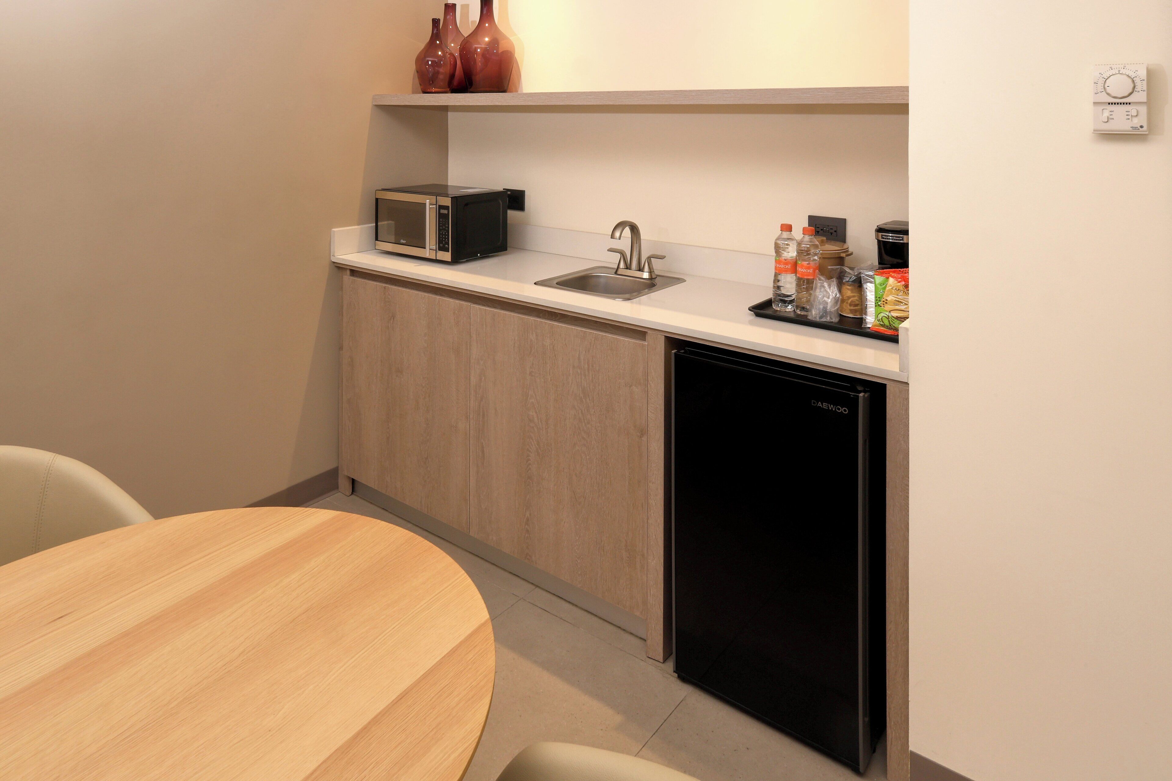 A compact kitchen with a microwave, sink, and dishwasher.