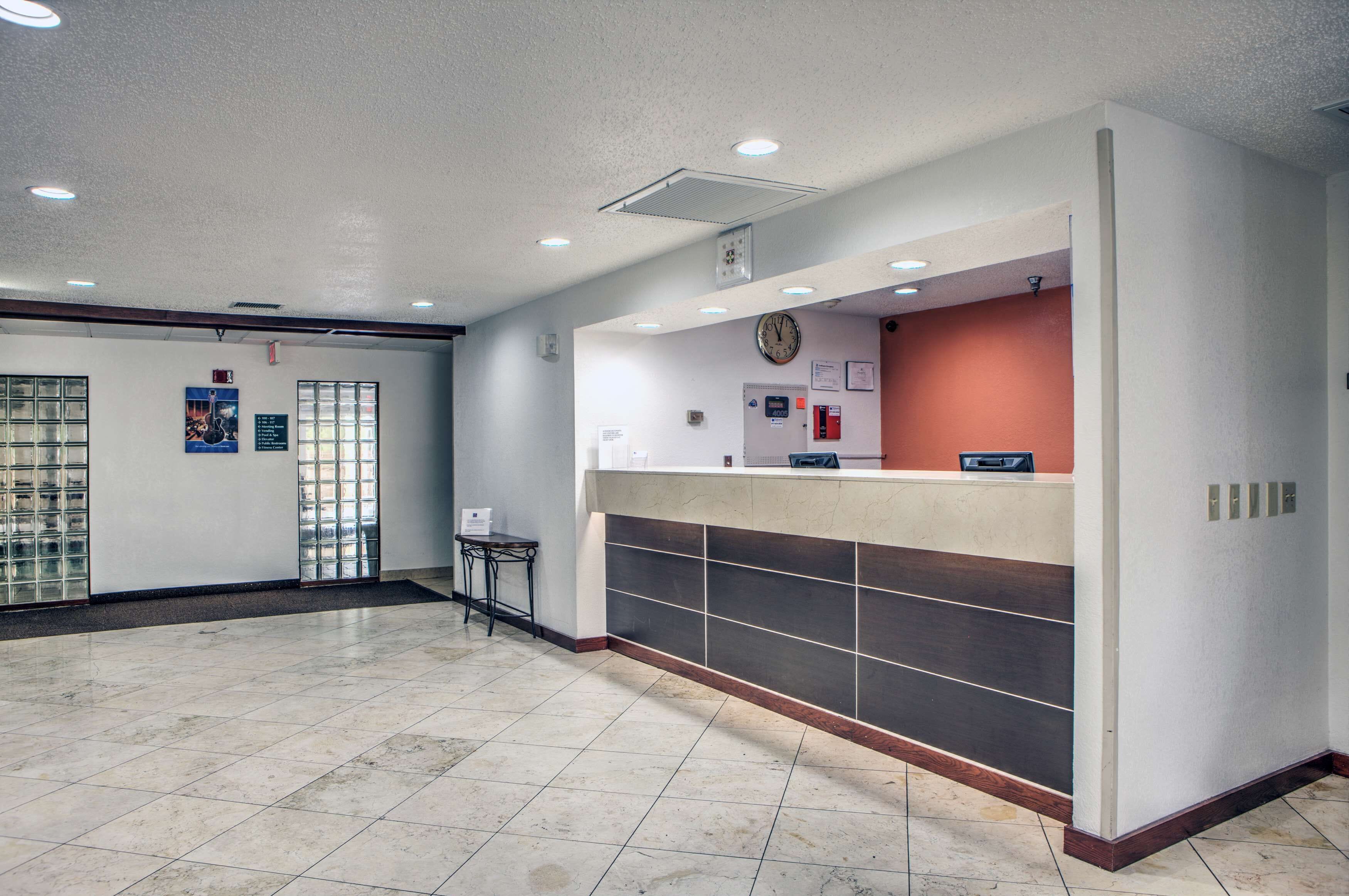 A reception area with a counter, a clock, and a door with glass panels.