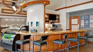 A bar area with a curved counter, bar stools, a beverage dispenser, and a coffee machine. - Hyatt Place Memphis/Wolfchase Galleria (Memphis)
