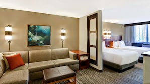 A hotel room with a sofa, a small table, a bed, and a painting on the wall. - Hyatt Place Memphis/Wolfchase Galleria (Memphis)
