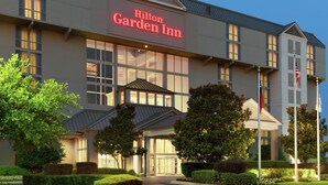 Un hôtel Hilton Garden Inn doté d’une architecture moderne, de grandes fenêtres et d’un jardin bien entretenu.